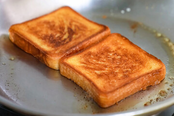 Cooking burger beef, toast on a hot frying pan close up. Preparing hamburger freshly baked, homemade. Grocery product advertising, menu.
