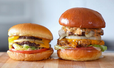 Burger beef cheese classic minimal close up on wooden board. Hamburger freshly baked on white plate, homemade. Grocery product advertising, menu or package.