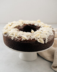 Pastel de chocolate con chocolate blanco encima. En fondo claro sobre base de pastel