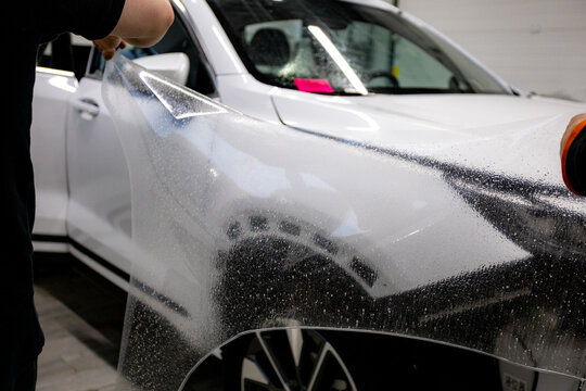 The process of installing PPF on a car. PPF is a protective film for paint that protects the paint from scratches and gravel.Anti-gravity protection. PFF is installed. Wrapping a car in close-up