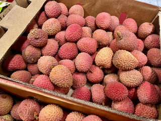 Lychees boxed for selling in a supermarket. Beautiful pink Christmas fruit 