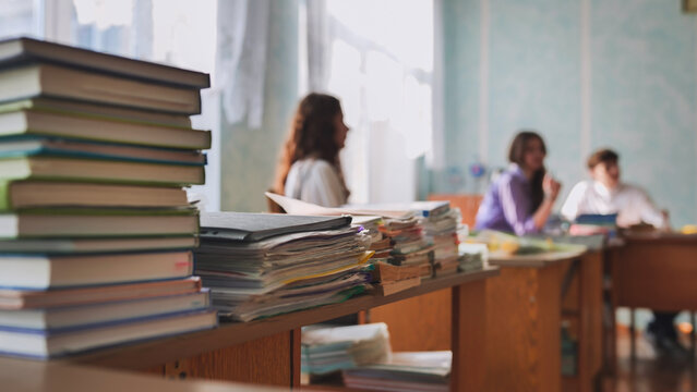 Stacks of books and notebooks in the school's teacher's lounge.