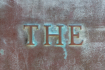 THE: Lettering THE on a bronze plate. Close-up of definite article THE on a bronze slab with...