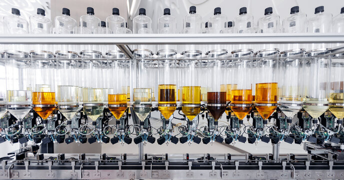 Automated perfume bottling Process, closeup of aroma water bottles being filled on automated production line
