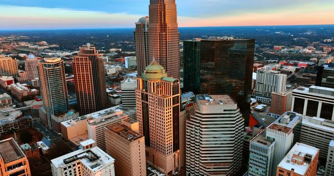 Orange light of sunset on the facades of skyscrapers. View of Charlotte downtown, United States from top.