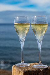 Pouring a glass of champagne on vacation, south of Fuerteventura, Canary islands, blue ocean, mountains