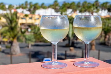 Glasses of cold white wine on roof terrace served outdoor in Corralejo, Fuerteventura in sunny day
