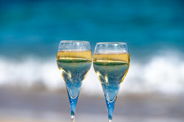 Pouring a glass of champagne on vacation, south of Fuerteventura, Canary islands, blue ocean, mountains