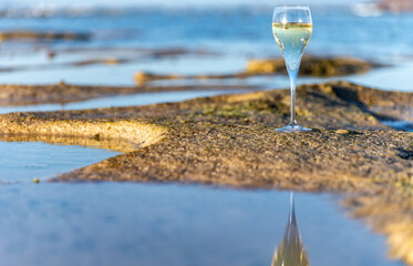 A glass of champagne or cava on vacation, low tide on Dunes Corralejo sandy beach, Fuerteventura,...