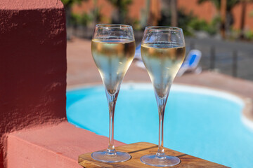 Pouring a glass of champagne on vacation, south of Fuerteventura, Canary islands, blue ocean, mountains