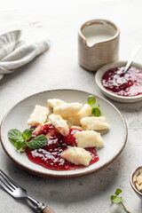 Lazy dumplings, vareniki with raspberry jam decorated with almond petals and mint leaves. Boiled...