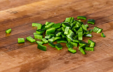 Healthy fresh meal cooking, chopped bell pepper on wooden board preparation. Homemade vegetables for menu, advert or package, close up, selective focus.