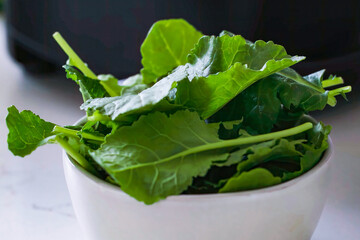 Healthy fresh meal cooking, greens in bowl. Homemade food preparation for menu, advert or package, close up, selective focus.