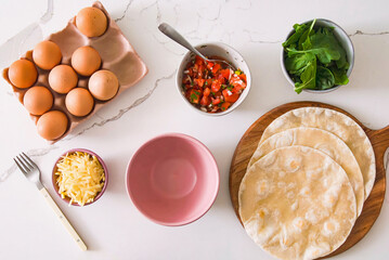 Healthy vegetarian breakfast preparation, pita bread with omelette and vegetables. Vegan meal for restaurant, menu, advert or package, close up, selective focus