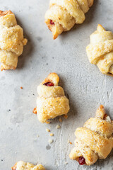 Homemade bagel cookies with dried fruits and walnuts on gray background top view. Sweet croissant cookies