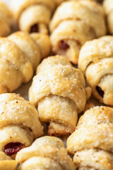Homemade bagel cookies with dried fruits and walnuts close up top view. Sweet croissant cookies