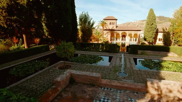 The Alhambra Palace - Palace of Partal displaying Moorish architecture, lush vegetation and reflective pools in Granada, Andalucia, Spain