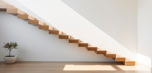 A sleek, modern staircase with floating wooden steps against a white wall, illuminated by natural light.