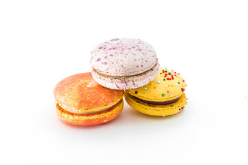 Sweet colorful yummy macarons isolated on white background. Brightly colored stacked macaroons. Tasty macaron. Three multi-colored orange, pink and yellow macaroons. French pastry, food concept