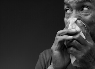 cold and flu blowing nose after catching the flu with grey black background with people stock image stock photo	