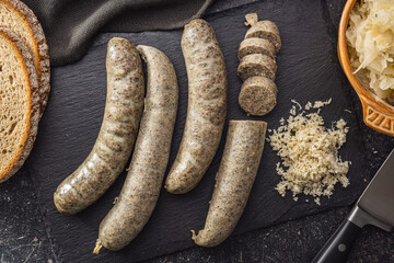 White pudding sausage. Pork product on cutting board on black table. Top view.