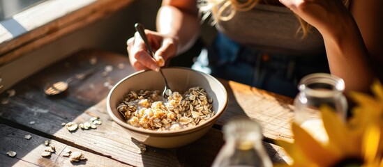 Young woman is resting and eating a healthy oatmeal after a workout. Copy space image. Place for adding text