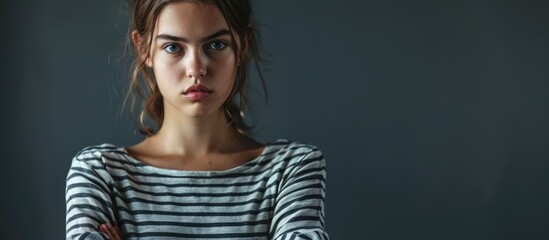 Young teenager girl wearing casual striped t shirt skeptic and nervous disapproving expression on face with crossed arms negative person. Copy space image. Place for adding text - obrazy, fototapety, plakaty