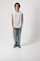 Confident and stylish Asian man posing over white wall. Vertical mock-up.