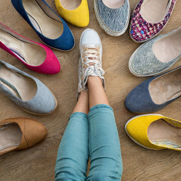 Detail von Frauenf&uuml;&szlig;en, umgeben von vielen Schuhen
