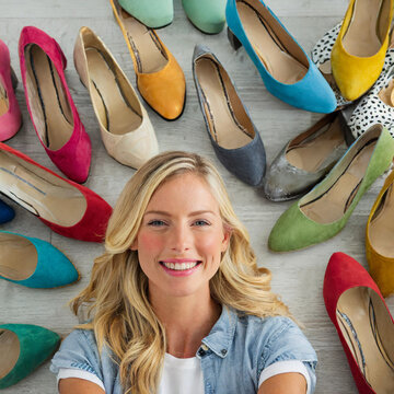 Eine h&uuml;bsche blonde Frau mit vielen Schuhen im Hintergrund (Konzept Frau und Schuhe)