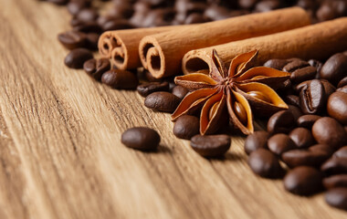 Coffee beans, cinnamon sticks and star anise on wooden background, close-up with copy space