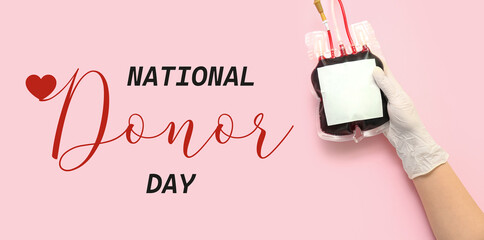 Awareness banner for National Donor Day with doctor's hand holding blood pack