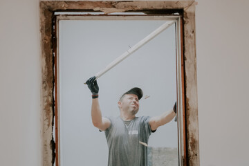 A man working with a crowbar in a doorway.
