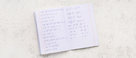 Copybook with maths formulas on light grunge background