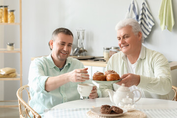 Mature brothers having breakfast in kitchen