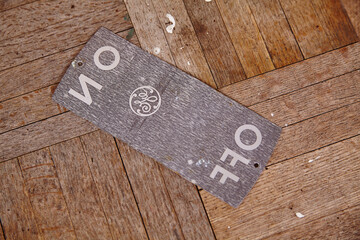 Back of Vintage Electrical ON OFF Nameplate on Wooden Texture