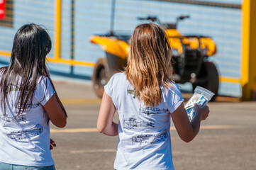 two women facing away, one with black hair and the other with blonde hair, with shirts reminiscent of old war planes