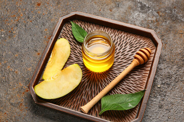 Tray with jar of sweet honey, apple and walnut on dark background