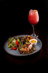 restaurant low carb rustic ceramic plate of grilled salmon with salad and motard toast close up capers top view with cocktail red fruits strawberry