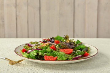 Plate with fresh vegetable salad on table