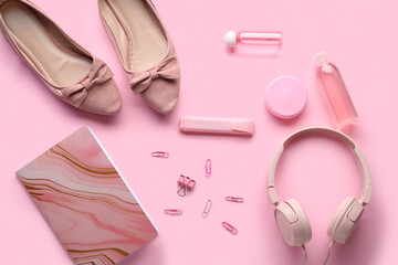 Composition with female shoes, modern headphones, bottles of cosmetic products and stationery on pink background