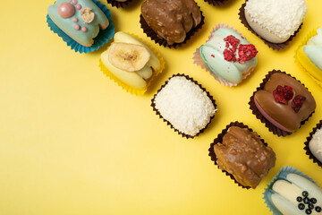 Set of different macaroons on yellow background top view, flat lay