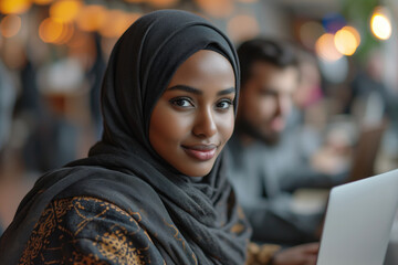 young woman in hijab working at a computer in a futuristic office