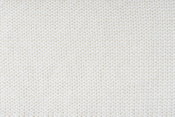 Close up background of knitted wool fabric made of viscose yarn, white color wool knitwear texture. Sweater, pullover knitted jersey background. Fabric abstract backdrop, wallpaper