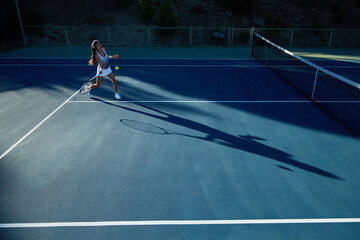 An asian girl plays tennis on a private court