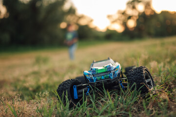Obraz premium Selective focus on an electric toy race car running in the grass in nature.
