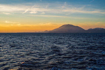 Beautiful sunset over the coast of sea, mountains and golden sky, Zakynthos, Greece