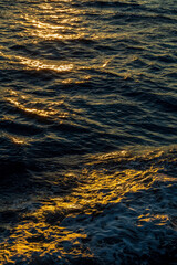 Rippled water surface at the sea during golden hour sunset close up
