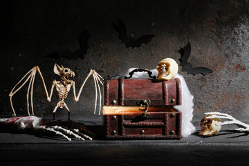 Composition with treasure chest and Halloween decor on dark background