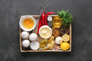 Bowl of fresh mayonnaise and ingredients on black background